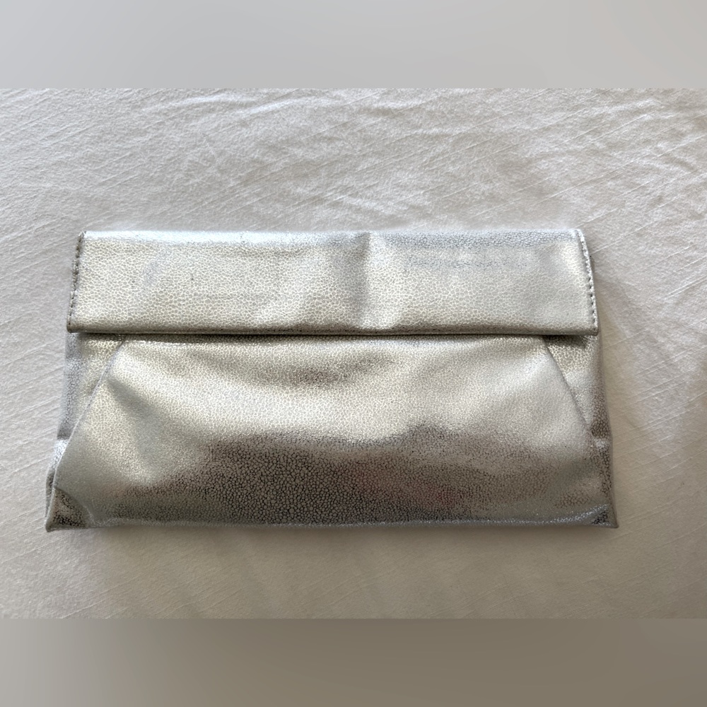 New with tags silver clutch, envelope style, magnetic closure, 13” wide x 7”